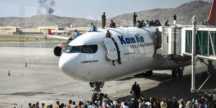 بالفيديو.. أفغان يتسلقون ويتشبتون بالطائرات في مطار كابول